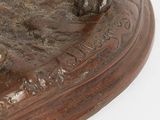 a bronze statue of a horse on a wooden base