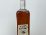 Gros plan sur une bouteille de rhum posée sur une surface blanche