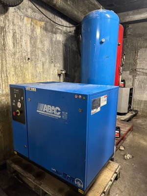 a blue compressor sitting on top of a pallet in a warehouse