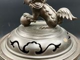silver plate with a dragon on top of it on a table