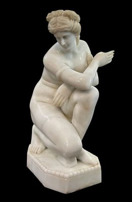 statue d'une femme assise sur un socle carré, les mains posées sur les genoux
