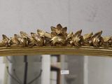 a mirror with a gold frame and a flower decoration on it