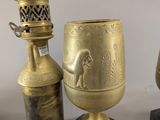three antique brass vases and a brass oil lamp on marble bases