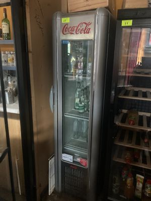 un réfrigérateur situé à côté d'une étagère où sont rangées des boissons