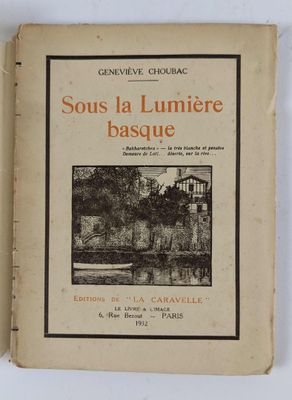 un vieux livre posé sur une table à côté d'un mur blanc