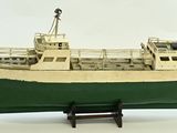 a model of a boat on a stand on a white surface