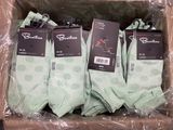 Plusieurs paires de chaussettes vertes se trouvent dans une boîte posée sur une table