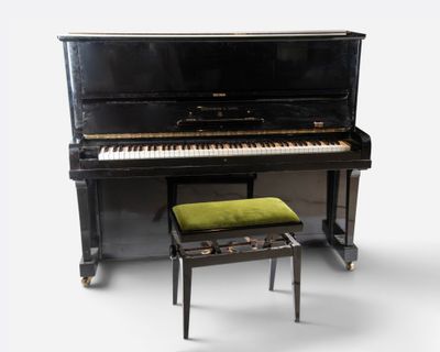 a piano and a stool sitting next to each other
