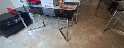 a glass table with a computer on it in a room