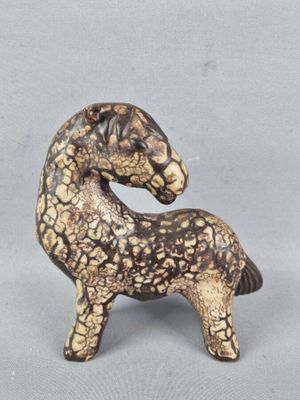 une figurine représentant un cheval posée sur une table