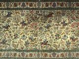 a close up of a rug with birds and flowers on it
