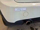 rear end of a white car with a sticker on the back of it