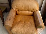 un fauteuil en cuir marron placé dans un coin d'une pièce