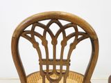 a wooden chair that has a wicker seat on it
