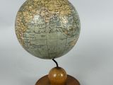 an old globe on a wooden stand with a white background