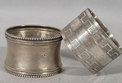 pair of antique silver napkins with designs on them on a table