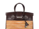 a brown and orange striped leather handbag with tassel