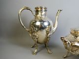 a silver tea pot and a silver teapot on a table