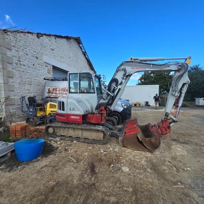 a small excavator that is parked outside of a building
