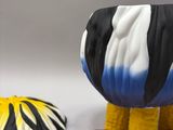 a black and white cow and a yellow and black and white cow