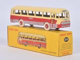 un petit bus jouet jaune et rouge posé sur une boîte jaune