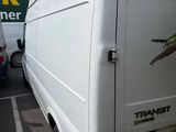 a white van parked in a parking lot next to other cars
