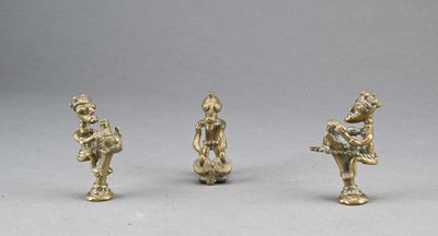 trois figurines en laiton représentant un homme et une femme jouant de la flûte