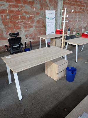 several desks and chairs in a room with a brick wall