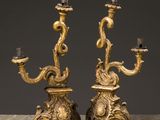 a pair of antique brass candelabs on marble table