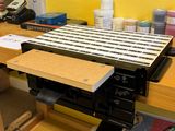 a keyboard and a printer on a workbench in front of a yellow wall