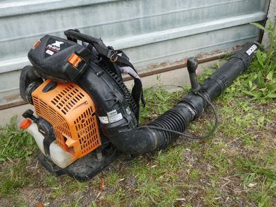 a small blower sitting on the ground next to a garage door