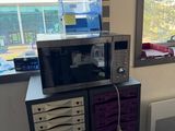 a microwave sitting on top of a cabinet next to a window