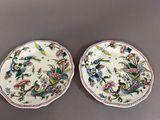 two plates with flowers and birds on them on a table