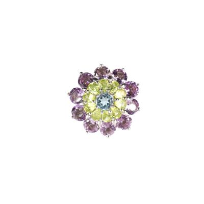 une photo en gros plan d'une bague sertie de pierres violettes et vertes