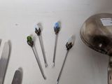 many different types of knives and spoons on the table