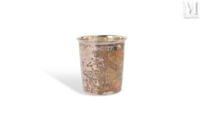 a silver cup that is sitting on a white surface
