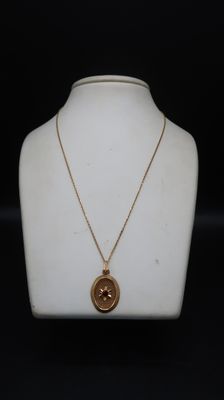 a close up of a necklace on a mannequin with a black background
