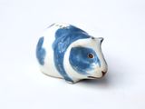 a small blue and white animal figurine on a white surface