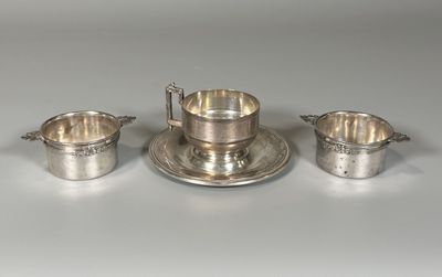 trois tasses et soucoupes en métal argenté posées sur un fond blanc