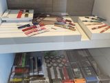 many different types of pens and pencils on the shelves