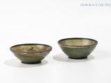 two bowls sitting on a white surface with a white background