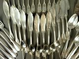 a lot of silver spoons and spoon spoons on the table