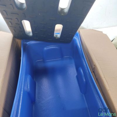 un toboggan en plastique bleu au milieu d'une boîte en carton
