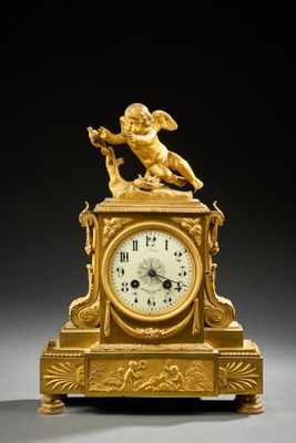 une horloge en or surmontée d'un ange
