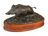 sculpture en bronze représentant un sanglier, posée sur un socle en bois, sur fond blanc