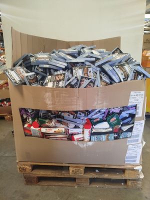 a cardboard box full of candy and candy bars on a pallet