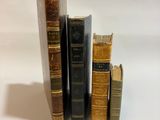 trois livres sont empilés sur une surface blanche