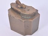 une petite boîte métallique munie d'un couvercle, posée sur une surface blanche