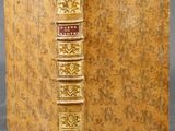 un vieux livre à la couverture dorée posé sur une table
