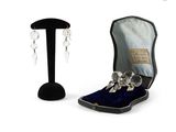 a pair of earrings sitting in a case next to a pair of earrings